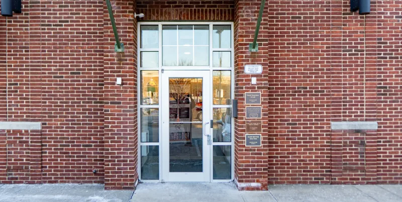 A glass door with a white frame set in a brick building.