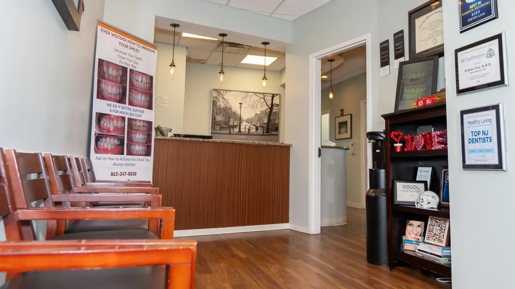 Dental office waiting area with a row of chairs and a reception desk.