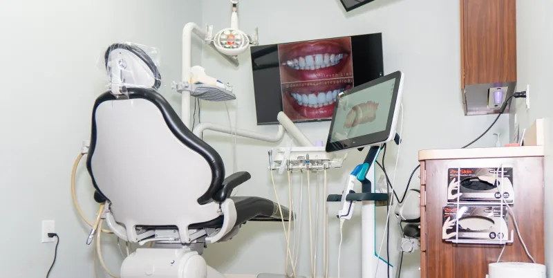 Modern dental chair in a clean dental office with dental equipment.